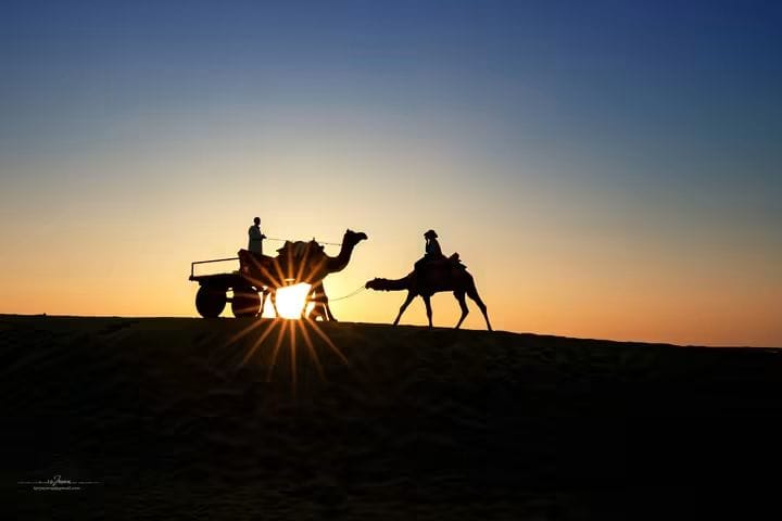 Travellers watching the sun set over an Indian landscape